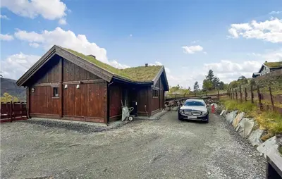 a car parked next to a building with a grass roof at Awesome Home In Hornindal With Wifi in Hornindal