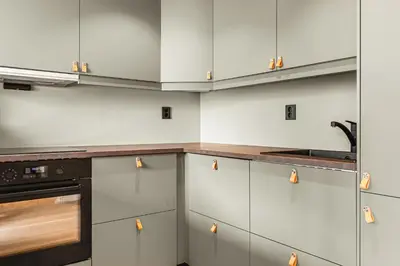 a kitchen with white cabinets and a sink at Odda Living - 3BR & 1BR - A3 in Tokheim