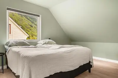 a bedroom with a bed and a large window at Odda Living - 3BR & 1BR - A3 in Tokheim