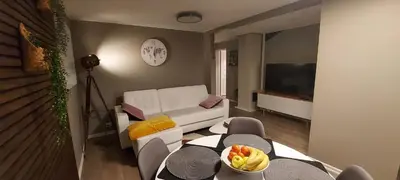 a living room with a white couch and a television at Cozy and warm just like at home, Free P, Big terrace in Langevåg
