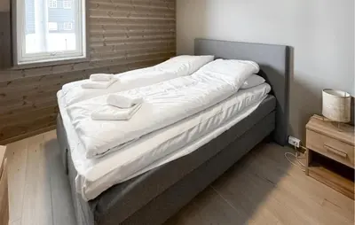 a large bed with white sheets on it in a room at Awesome Apartment In Geilo With Sauna in Geilo