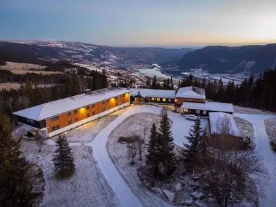 a building with lights on in the snow at Øyer Fjellstugu in Øyer