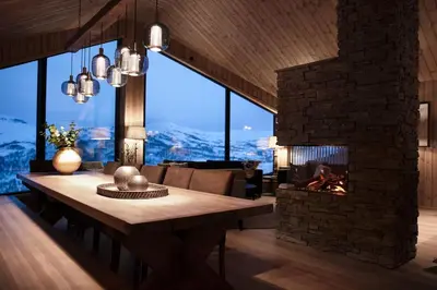 a living room with a table and a fireplace at The View - Hodlekve in Sogndal