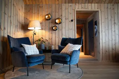 two chairs and a lamp in a room with wooden walls at The View - Hodlekve in Sogndal