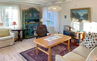a living room with a table and a chair at 4 Bedroom Cozy Home In Svorkmo in Brattli