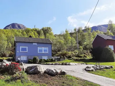 a blue house on the side of a road at 6 person holiday home in Åram-By Traum in Sandvik