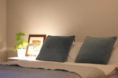 a bed with two pillows and a picture on it at Førde sentrum - Lindbøen Gjesterom in Førde