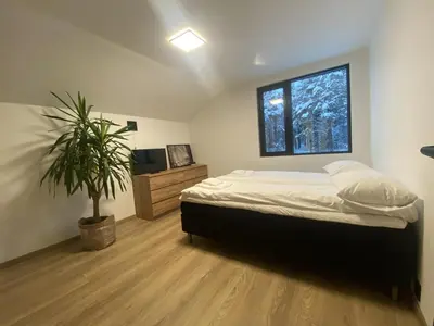 a bedroom with a bed and a potted plant at Newly renovated apartment with a central location in Geilo
