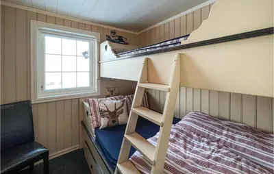 a small bedroom with bunk beds and a window at 5 Bedroom Awesome Home In Røn in Ron