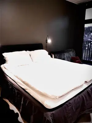 a bed with white sheets and pillows in a bedroom at Topp studio leilighet Alpine Lodge in Trysil