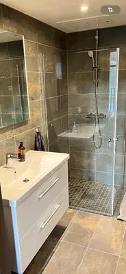 a bathroom with a white sink and a shower at Topp studio leilighet Alpine Lodge in Trysil