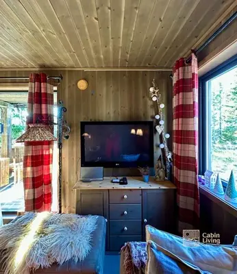 a living room with a flat screen tv and a couch at Cozy apartment ski in out, BBQ & Wifi Sjusjøen in Sjusjøen