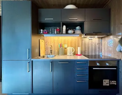 a kitchen with blue cabinets and a sink at Cozy apartment ski in out, BBQ & Wifi Sjusjøen in Sjusjøen