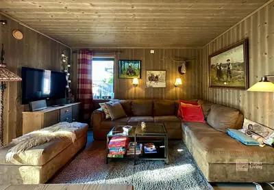 a living room with a couch and a tv at Cozy apartment ski in out, BBQ & Wifi Sjusjøen in Sjusjøen