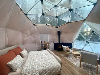 a bedroom with a bed in a tent at Dome Glamping with shared bathroom in Lillehammer