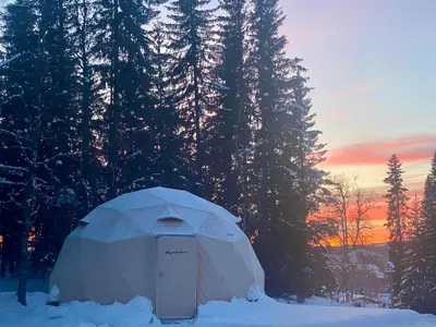 a dome tent in the snow in front of trees at Dome Glamping with shared bathroom in Lillehammer