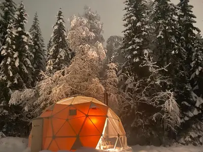 an orange dome tent in the snow next to trees at Dome Glamping with shared bathroom in Lillehammer