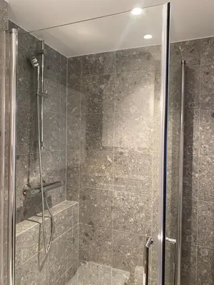 a bathroom with a shower with a glass door at Entire renovated apartment from 1780 with Kitchen, Bath, Bedroom, and Living Room in Skuteviken in Bergen