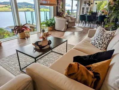 a living room with a couch and a table at Nyoppusset hus med utsikt. in Steinkjer