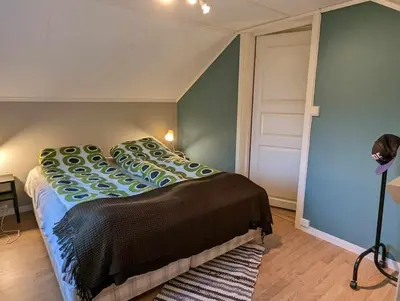 a bedroom with a bed with a blue wall at Nyoppusset hus med utsikt. in Steinkjer