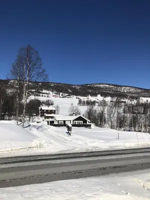 a person riding a snowboard down a snow covered road at Stugu - Koselig hytte med sentral beliggenhet in Åker