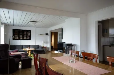 a dining room and living room with a table and chairs at Osloveien 6 in Røros