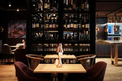 a restaurant with two tables and bottles of wine at Bergmannsgata 3 in Røros