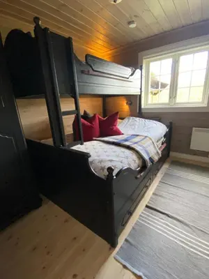 a bedroom with a bunk bed with red pillows at Bjørnebuhytten, Geilo, 13 sengeplasser med privat Jacuzzi og el-bil-lading in Geilo