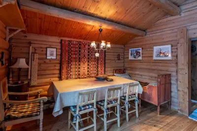 a dining room in a log cabin with a table and chairs at Trysilfjellet sør 318 in Trysil