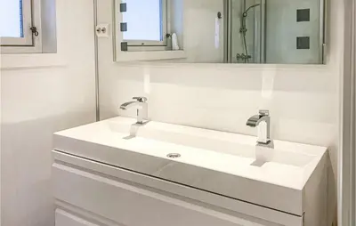 a white bathroom with two sinks and a mirror at Lovely Home In Stadlandet in Stadlandet