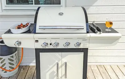 a grill on a deck with a bowl of food at Lovely Home In Stadlandet in Stadlandet