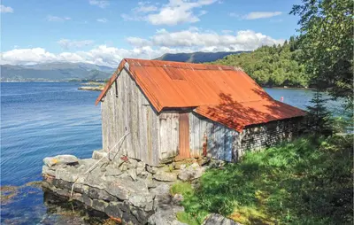 an old building on the side of a body of water at Lovely Home In Stadlandet in Stadlandet