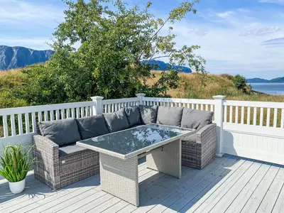 a patio with a couch and a table on a deck at Holiday Home Sjøtun by Interhome in Hyllestad