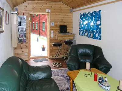 a living room with two leather chairs and a table at Holiday Home Kalavåg by Interhome in Kalavåg
