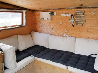 a couch in the corner of a tiny house at Holiday Home Kalavåg by Interhome in Kalavåg
