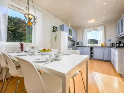 a kitchen with a white table and chairs at Chalet Seievika by Interhome in Brekke