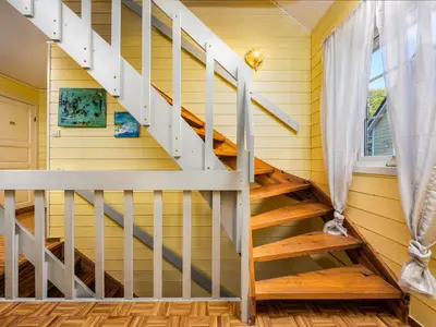 a staircase in a house with yellow walls and wooden floors at Chalet Seievika by Interhome in Brekke