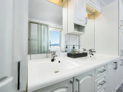 a white bathroom with a sink and a mirror at Chalet Seievika by Interhome in Brekke