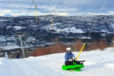 a person sitting on a snowmobile in the snow at Active Adventure Base - Apartment & Lavvo, Dagali Fjellpark in Dagali