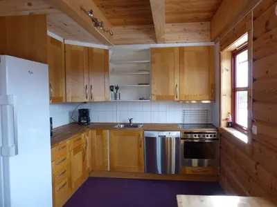a kitchen with wooden cabinets and a sink and a stove at Active Adventure Base - Apartment & Lavvo, Dagali Fjellpark in Dagali
