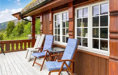 two chairs and a table on the porch of a cabin at 4 Bedroom Awesome Home In Nordfjordeid in Nordfjordeid