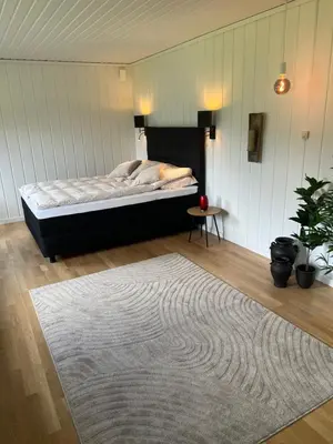 a bedroom with a bed and a rug on the floor at Tunold Gård - Olahuset in Oppstryn