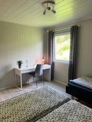 a bedroom with a desk and a chair and a window at Tunold Gård - Olahuset in Oppstryn