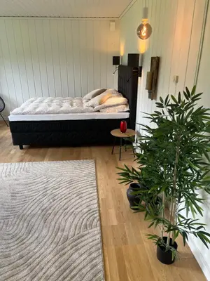 a bedroom with a bed with plants and a rug at Tunold Gård - Olahuset in Oppstryn