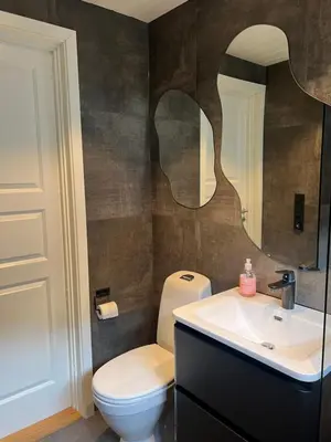 a bathroom with a toilet and a sink and a mirror at Tunold Gård - Olahuset in Oppstryn
