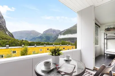 a balcony with a table and a view of mountains at Trolltunga Hostel in Tysso