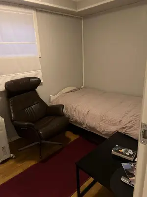 a small room with a bed and a chair at Trondheim, Kroppanmarka Tiller in Trondheim