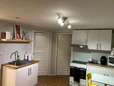 a kitchen with white cabinets and a sink at Trondheim, Kroppanmarka Tiller in Trondheim