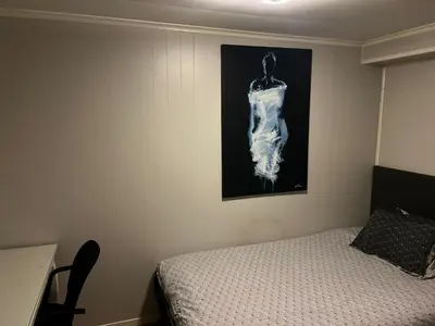 a bedroom with a bed and a painting on the wall at Trondheim, Kroppanmarka Tiller in Trondheim