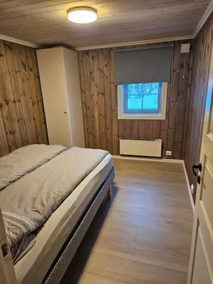 a bedroom with a bed in a room with a window at Hytte i Ringsaker (Ljøsheim/Sjusjøen) in Ringsaker